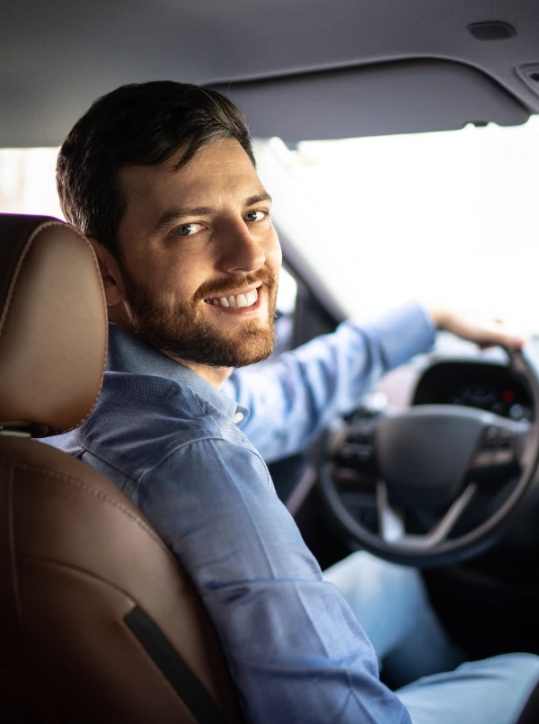 Uśmiechnięty mężczyzna za kierownicą